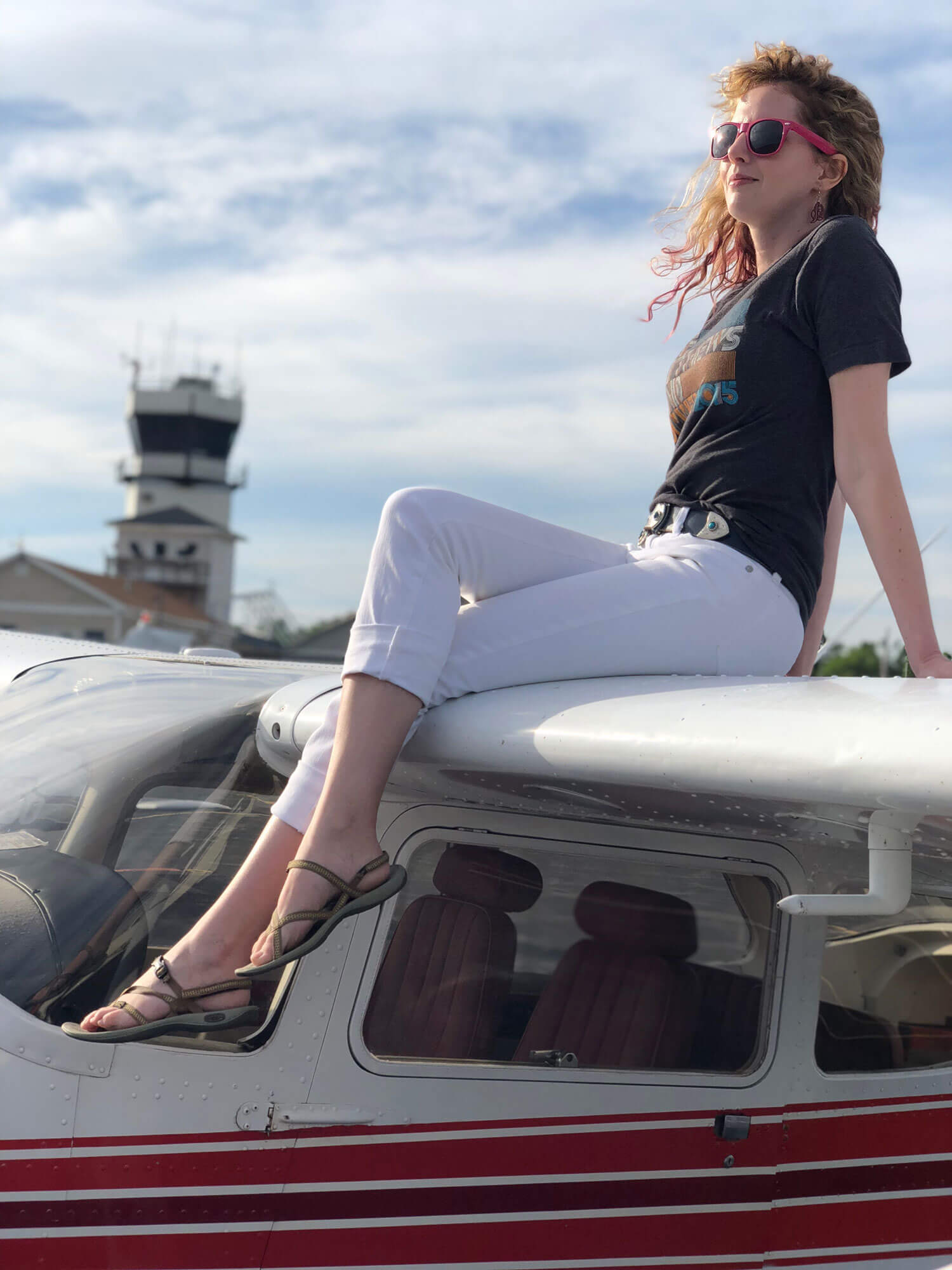 Kim Hosty, enjoying the sunshine while seated upon the wing of an airplane